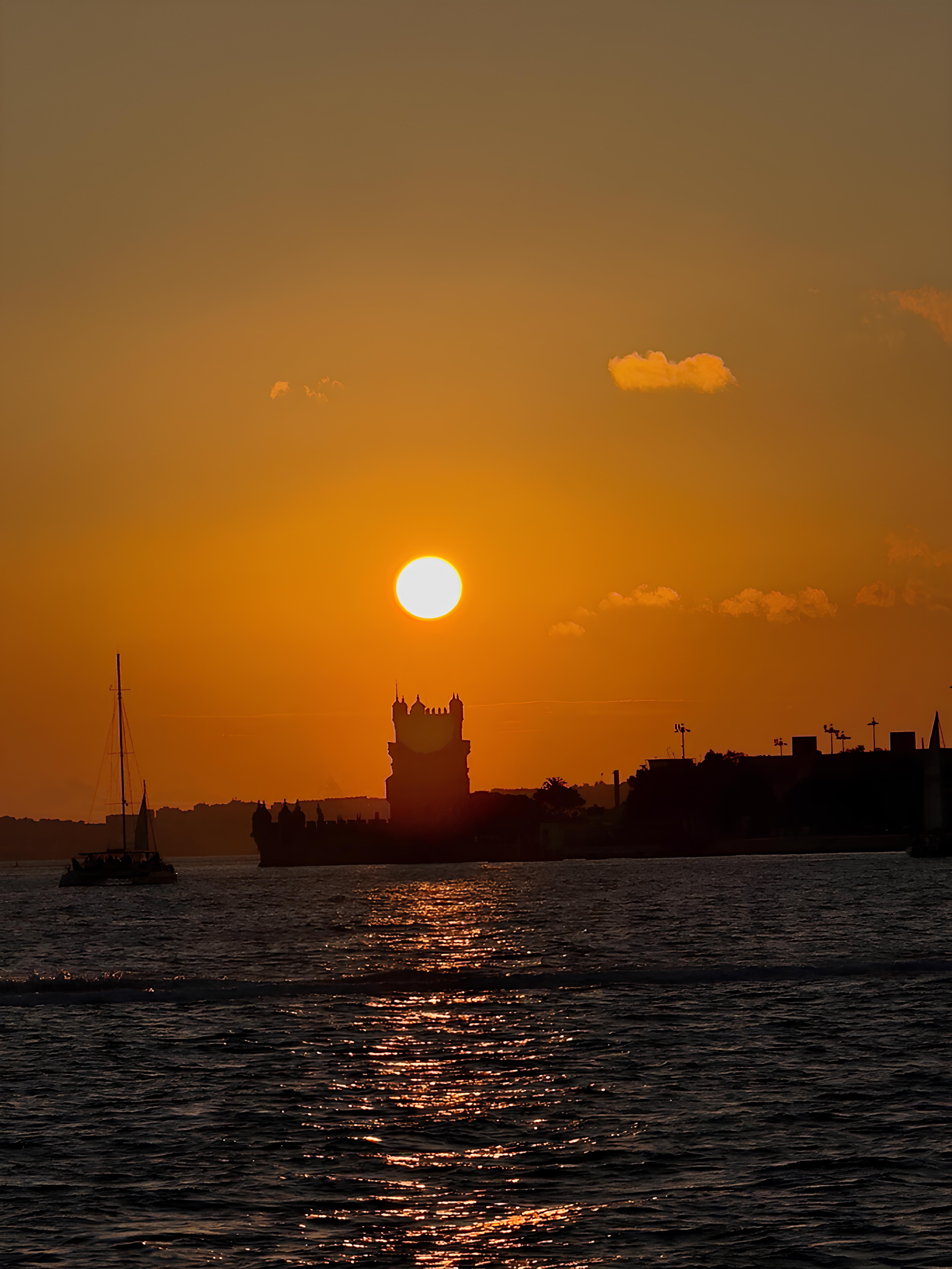 Belém Tower silhouetted against a golden sunset on the Tagus River, Lisbon
